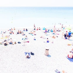 People at beach against clear sky