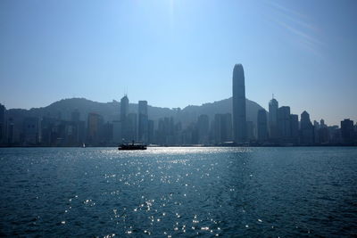 City at waterfront against blue sky