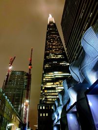 Low angle view of illuminated buildings against sky at night