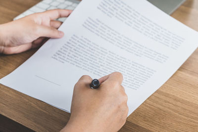 High angle view of person reading book on table