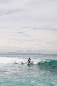 Man surfing on sea against sky