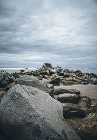 Rocks by sea against sky