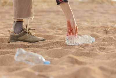 Low section of man standing on sand at beach