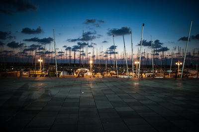 Row of illuminated boats against sky at sunset