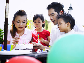 Family celebrating birthday in lawn