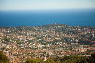 High angle view of townscape by sea against sky