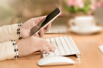 Midsection of person using laptop on table