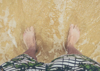 Low section of woman in water at beach