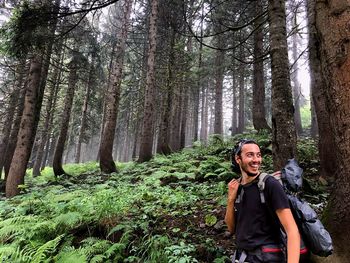 Male hiker smiling while standing in forest