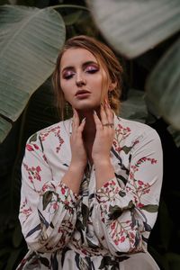 Young woman standing against plants in park