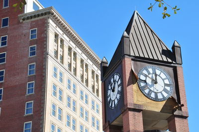 Low angle view of clock against sky