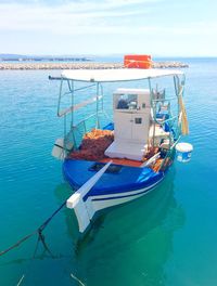 Boat moored on sea against sky