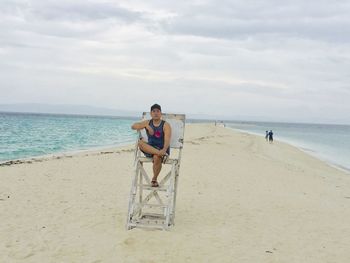Boy on beach against sky