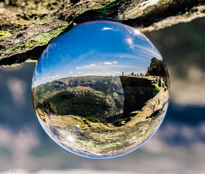 Close-up of crystal ball against trees