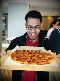 Portrait of a surprised young man with pizza