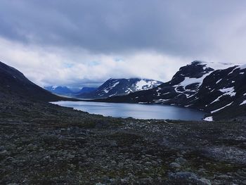 Scenic view of lake by mountains against sky