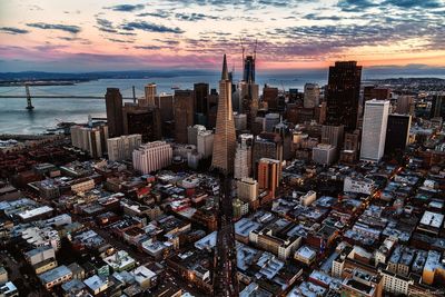 Aerial view of cityscape against cloudy sky