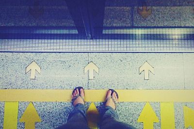 Low section of person standing on tiled floor