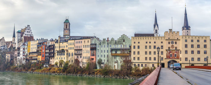 Buildings in city against cloudy sky