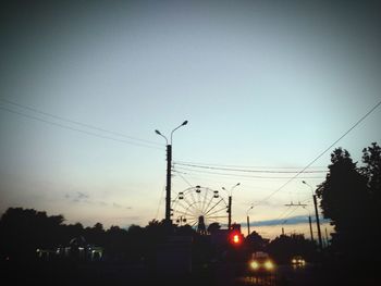 Cars on road against sky during sunset