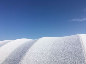 Low angle view of land against clear blue sky