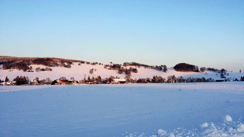 Scenic view of snow covered landscape against clear sky