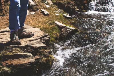 Low section of man standing on rock