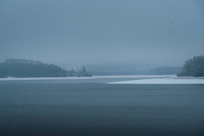 Scenic view of lake against sky during winter