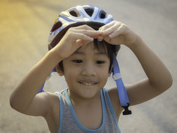 Close-up of cute boy wearing helmet standing outdoors