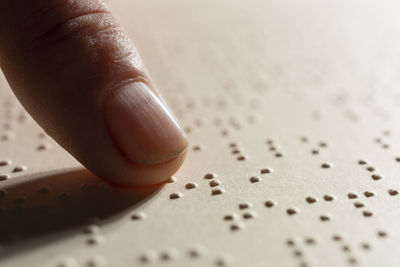 A finger following the reading of a page written in the braille alphabet, the tactile reading system