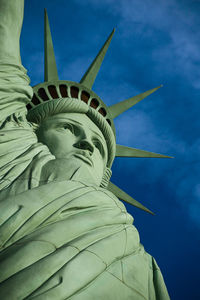 Low angle view of statue of liberty against cloudy sky