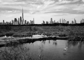 Scenic view of river by buildings against sky