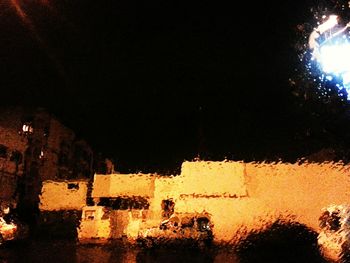 Illuminated buildings against sky at night