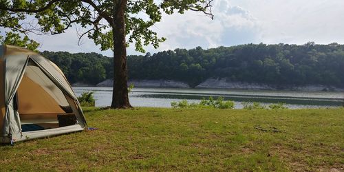 Scenic view of lake by trees against sky