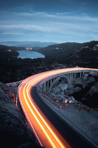 High angle view of light trails on road against sky at dusk