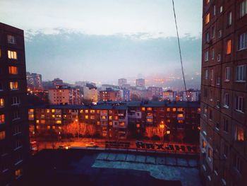 Illuminated buildings against sky at dusk