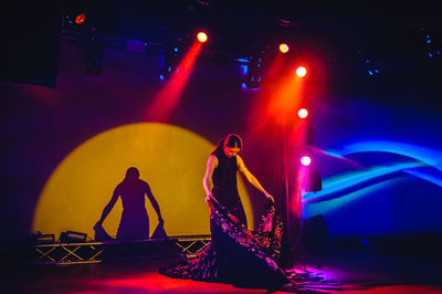 People dancing in illuminated stage