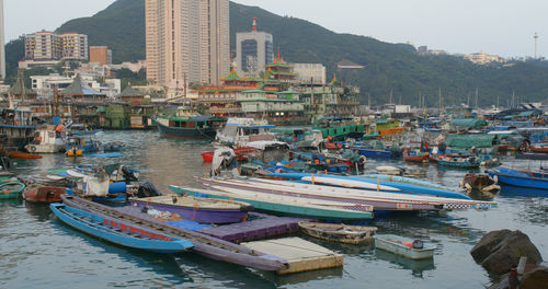 Boats moored at harbor in city