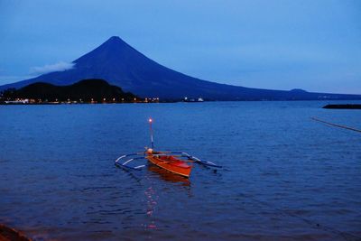 Scenic view of calm sea against mountain range