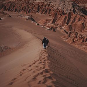 High angle view of people walking on sand