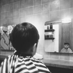 Rear view of boy standing in bathroom