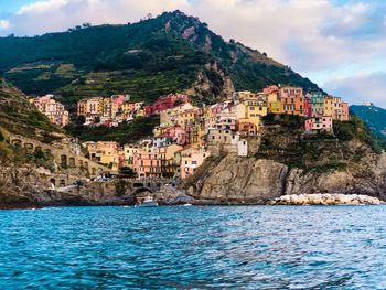 Scenic view of sea by buildings against sky