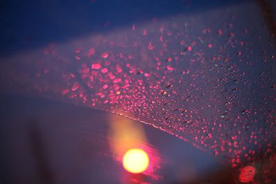 Close-up of wet glass window at night