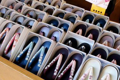 Colorful footwear arranged in boxes at store for sale