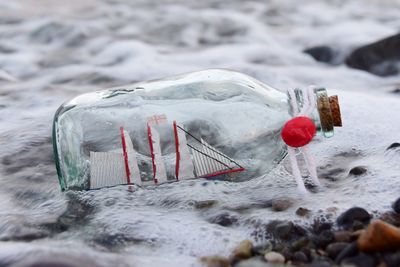 Close-up of bottle on shore