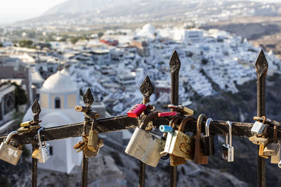 High angle view of padlocks hanging on railing against buildings