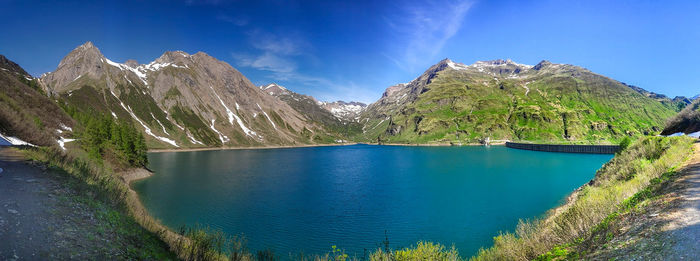 Panoramic view of lake and mountains against blue sky