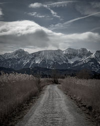 Road amidst snowcapped mountains against sky