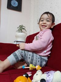 Cute girl sitting with toy at home