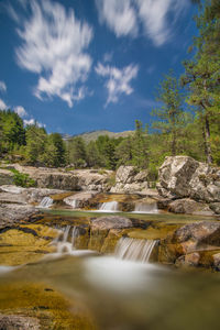 Scenic view of waterfall against sky